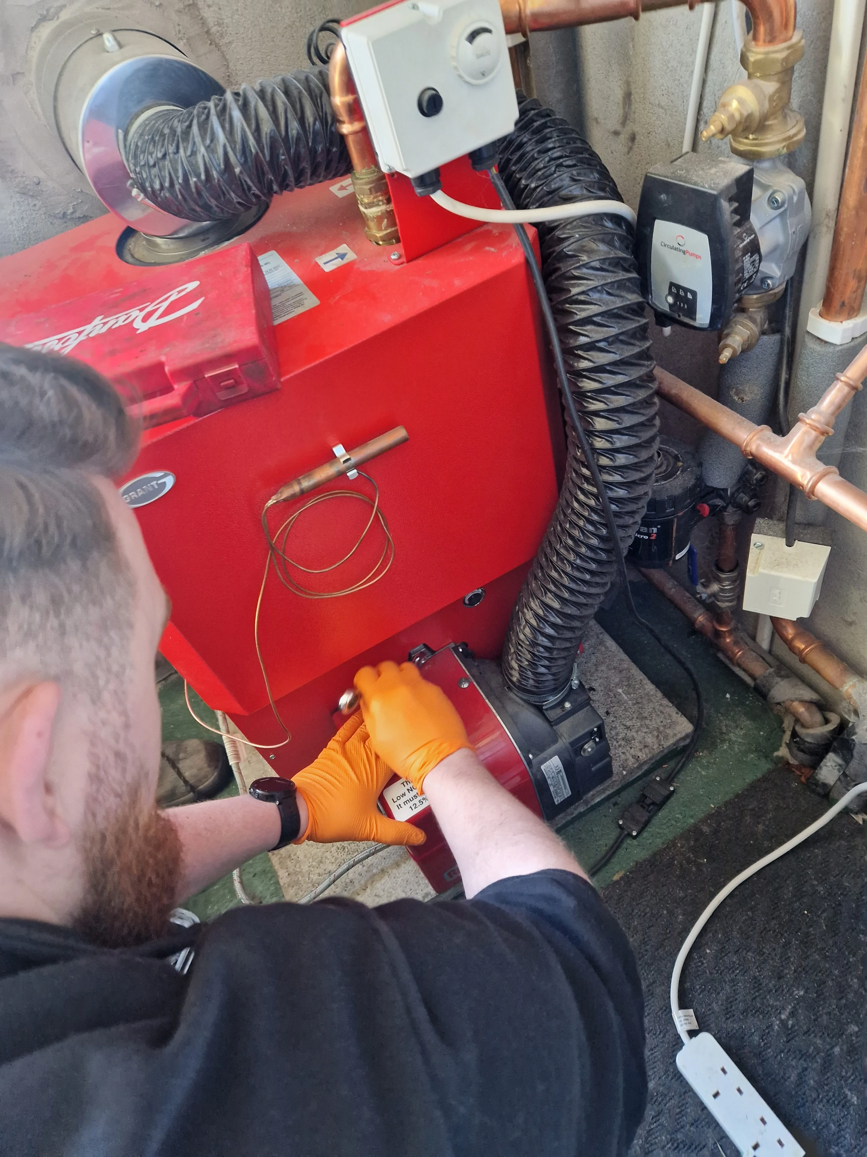 Kieran Kelly working on a Grant oil boiler installation — Lisburn, Northern Ireland
