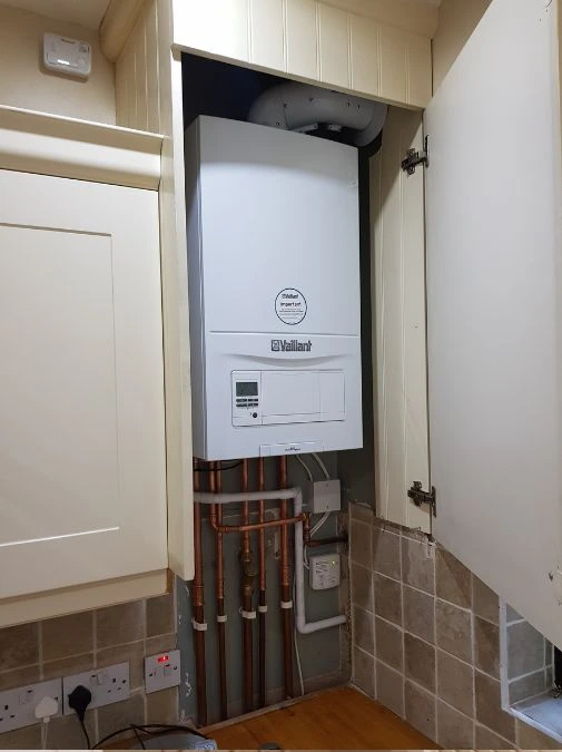 Combi boiler installed neatly in a Belfast kitchen cupboard — Kelly Heating NI